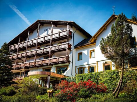 Charmante Fassade des Holzschuh's Schwarzwaldhotels umgeben von grüner Natur, eine malerische Kulisse für Silvester.
