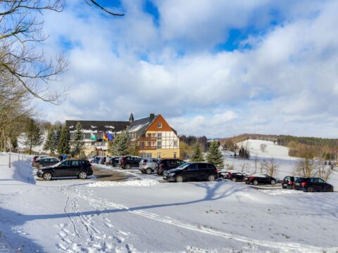 Schneebedecktes Panorama Berghotel Wettiner Höhe, bereit für Silvesterfeierlichkeiten.