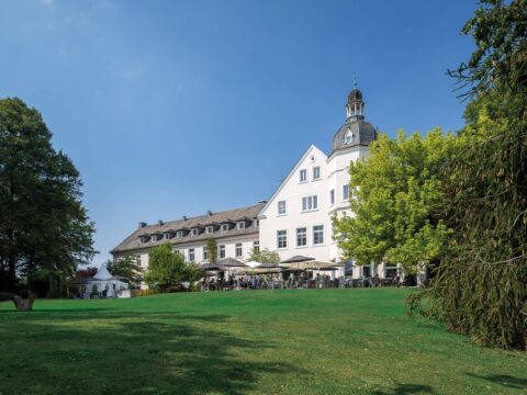 Feiern Sie Silvester im Hotel Haus Delecke, gezeigt mit seinem idyllischen Garten.